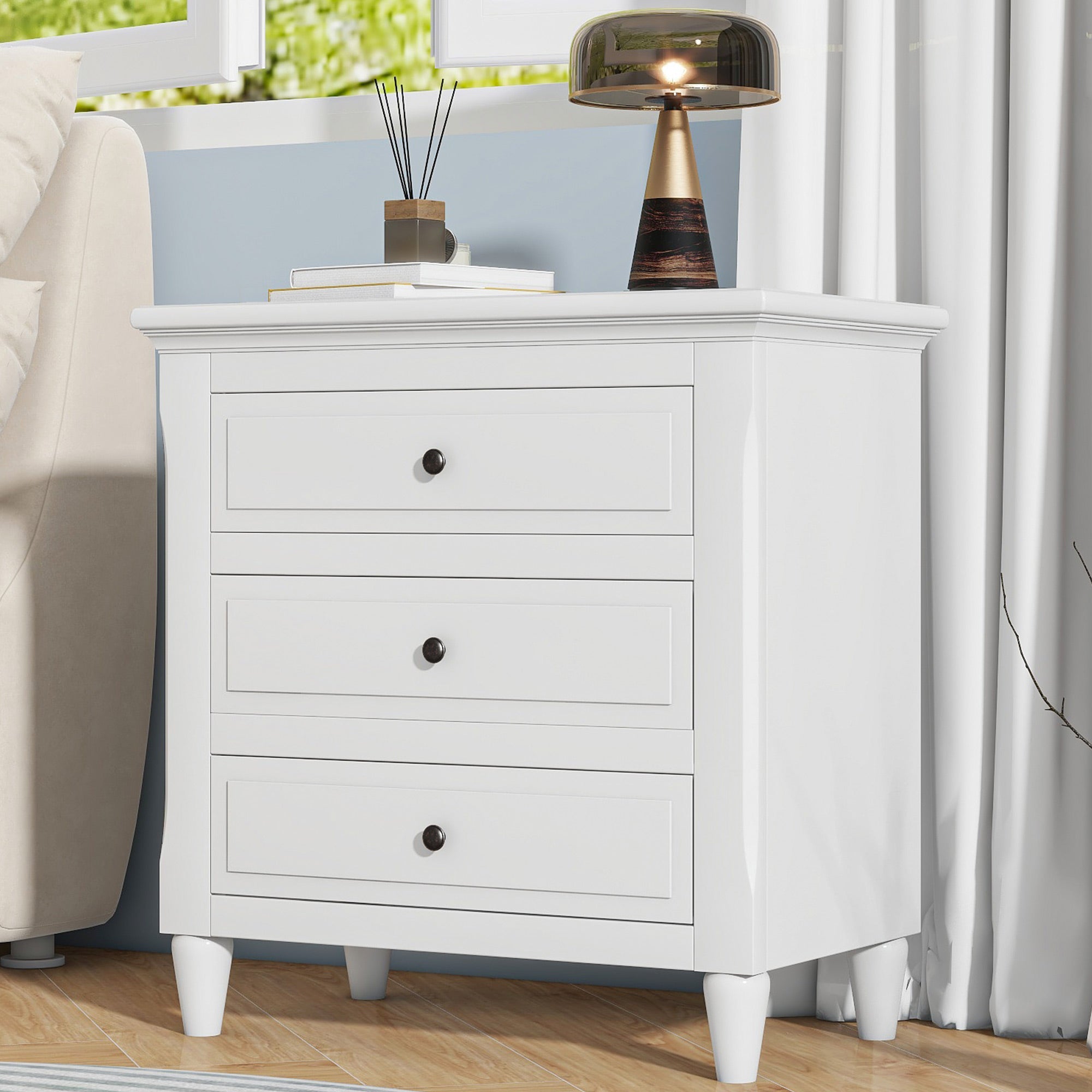 Painted 3-drawer bedside cabinet with metal handles, angled view