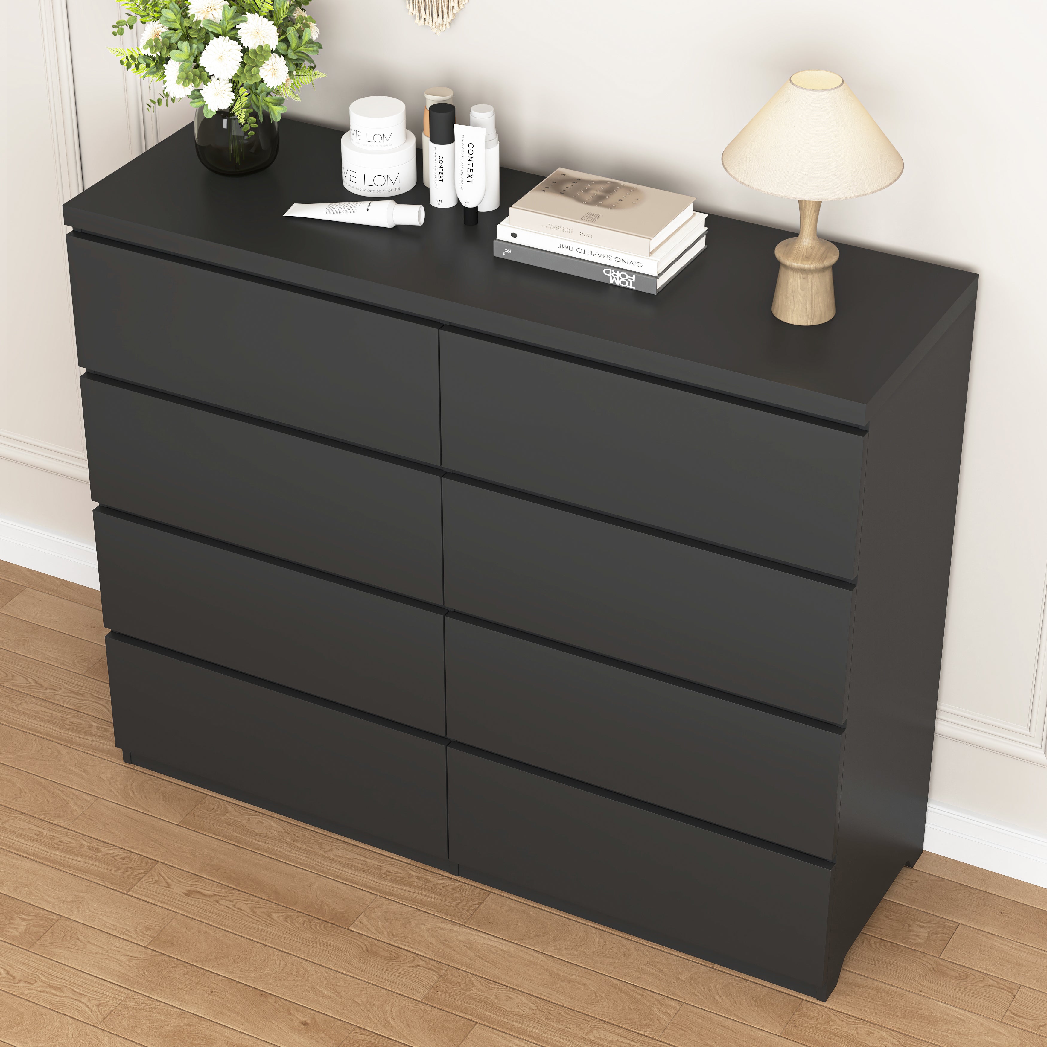 8-drawer black dresser styled in a modern bedroom