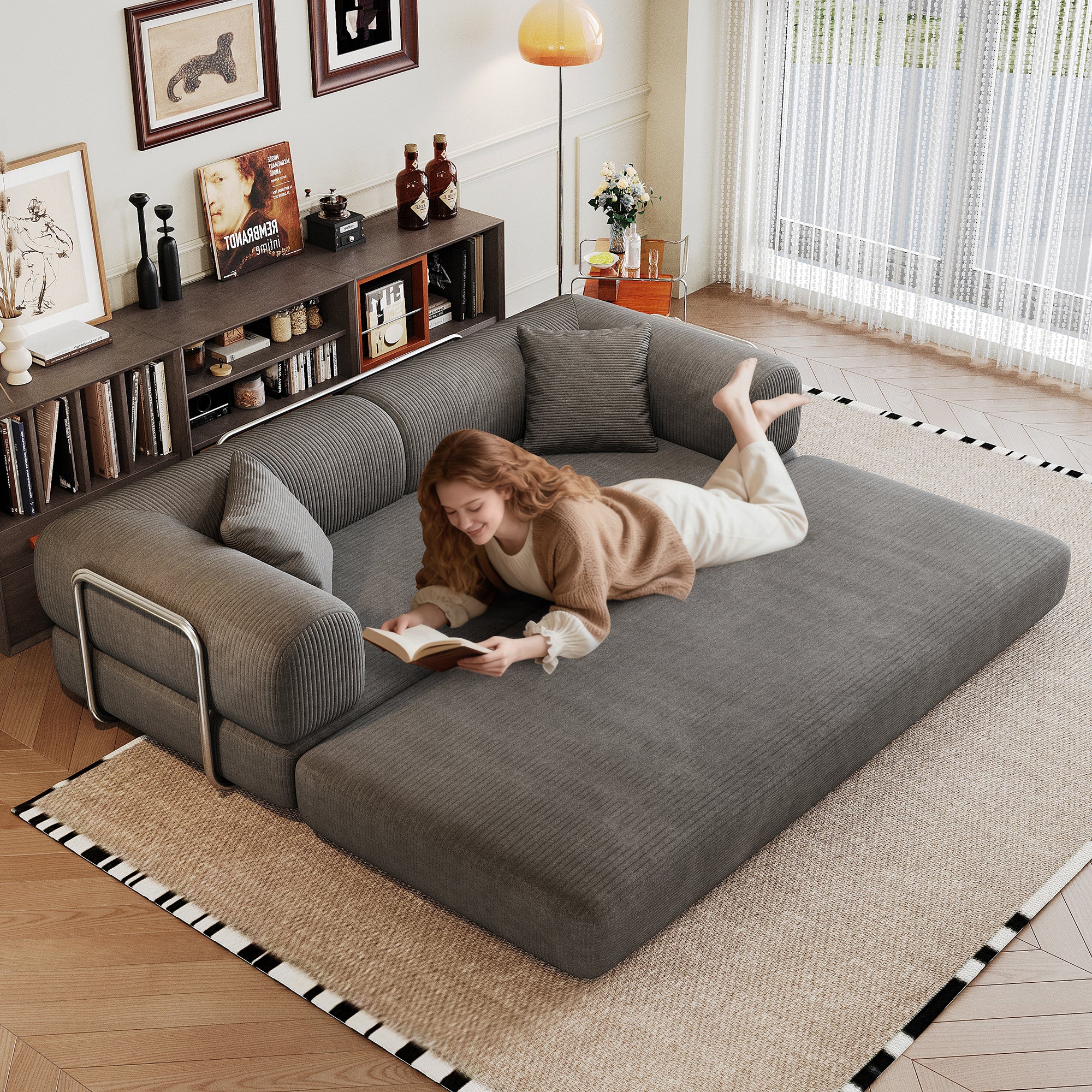 Grey corduroy convertible sofa bed, angled view showing pillow back and armrest