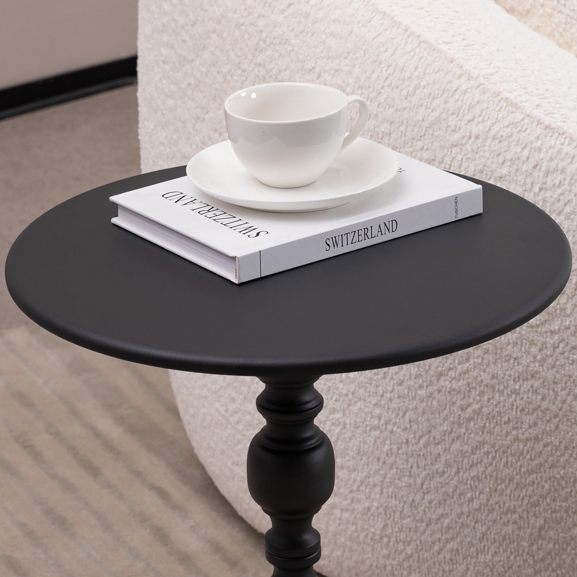 Round metal side table styled beside a sofa in a living room