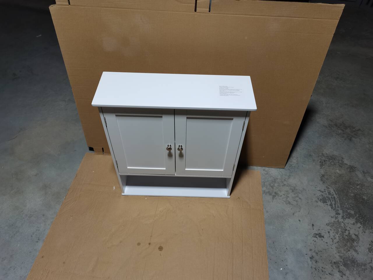 White over-toilet storage cabinet installed above toilet, room view