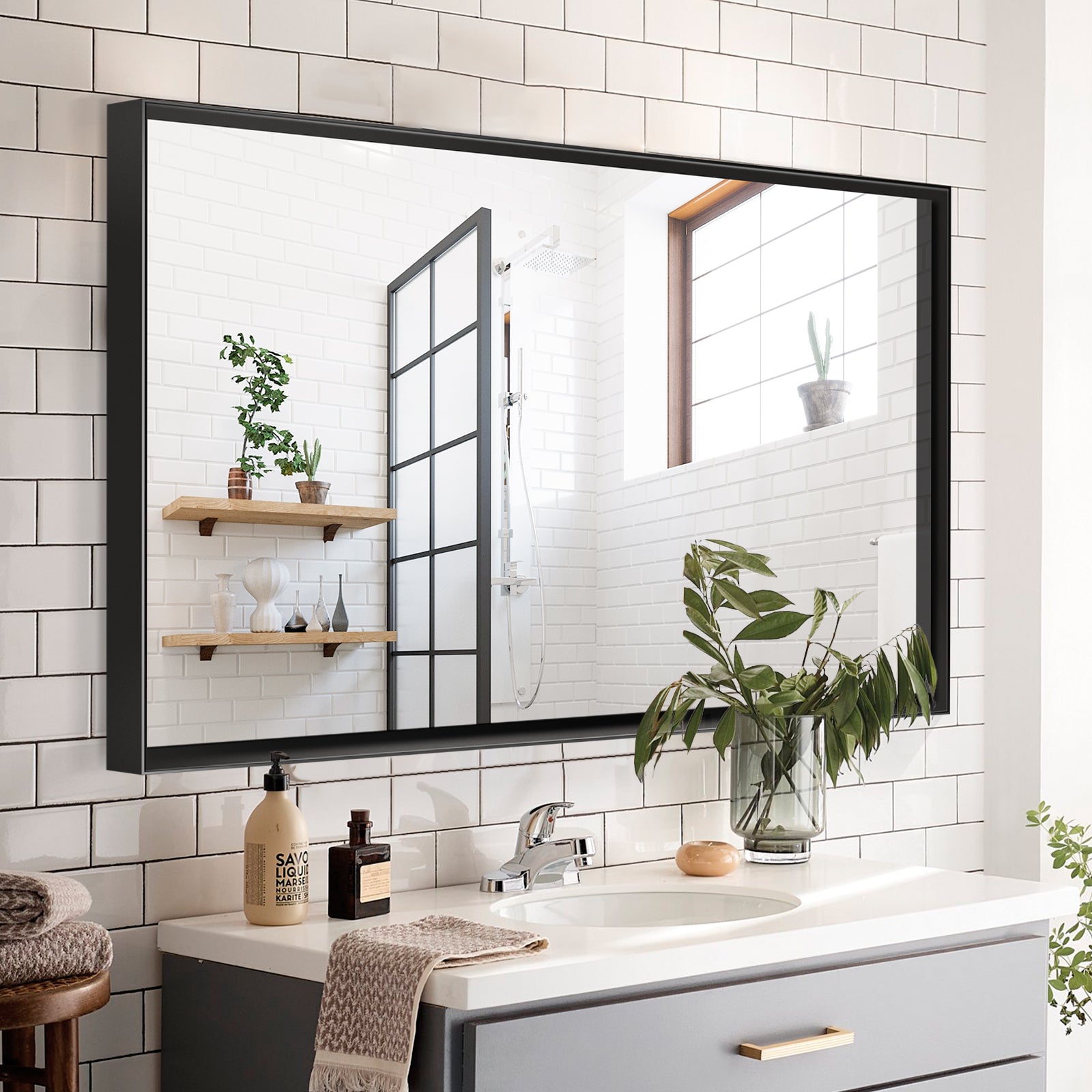 Glossy black metal framed bathroom mirror mounted horizontally, wall view