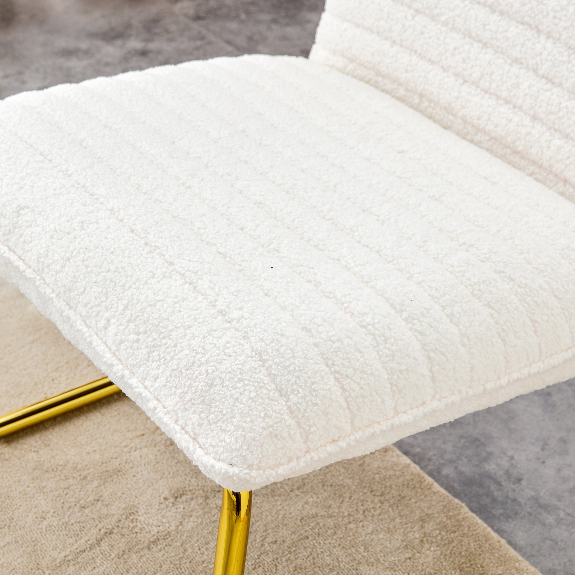 One White minimalist armless sofa chair with plush cushion and backrest paired with golden metal legs, suitable for offices, restaurants, kitchens, bedrooms