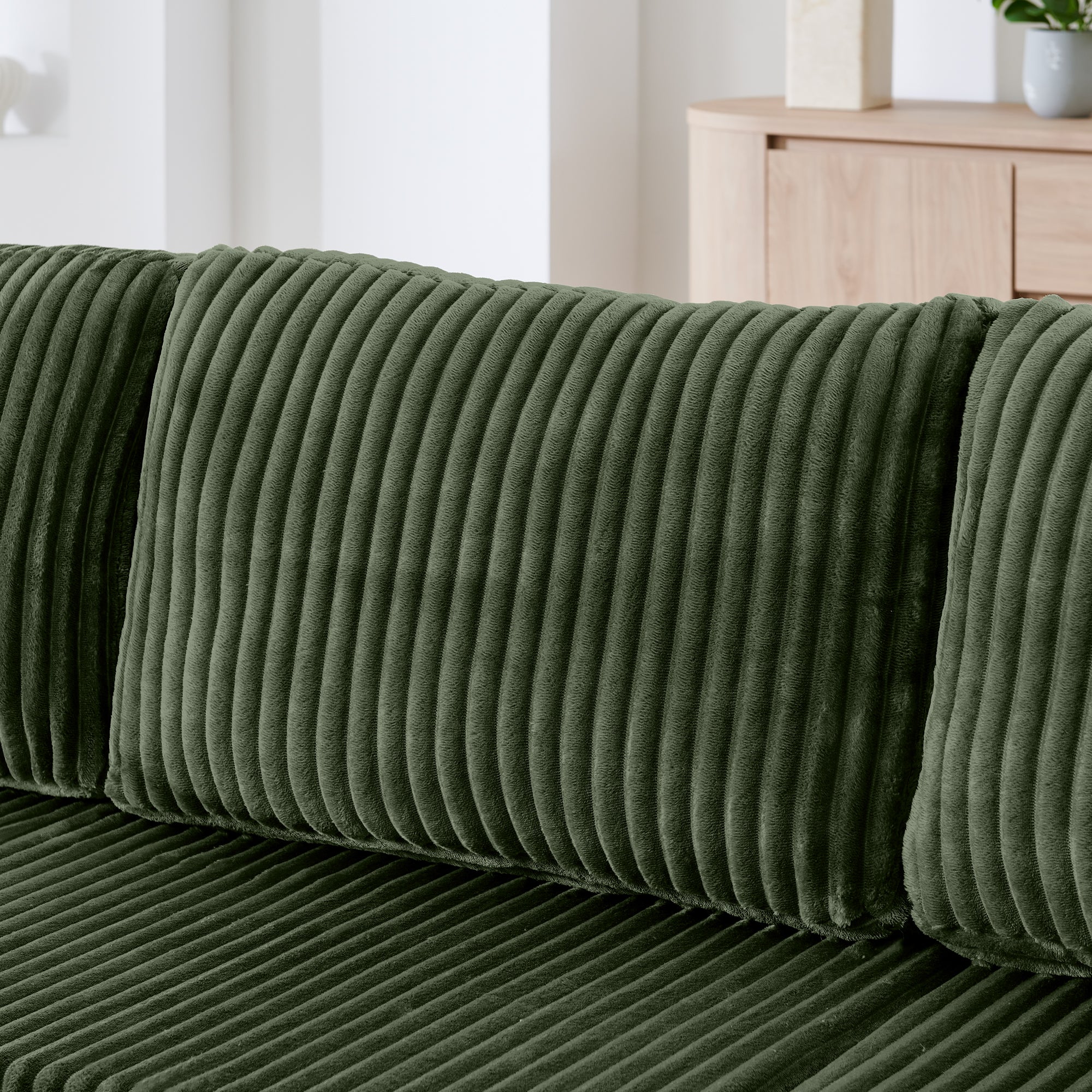 Green corduroy sectional sofa in modern minimalist living room setting