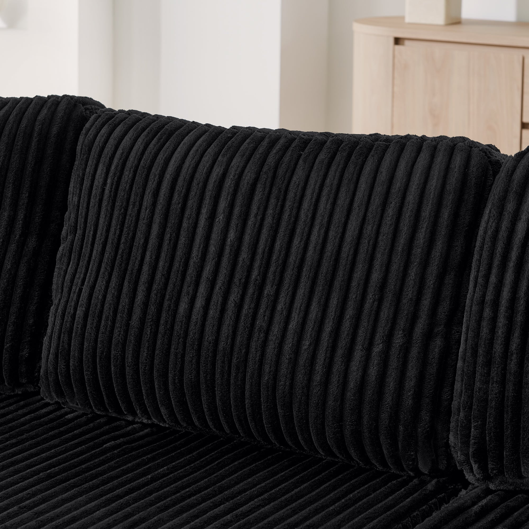 U-shape sleeper sofa in black corduroy, corduroy fabric texture close-up